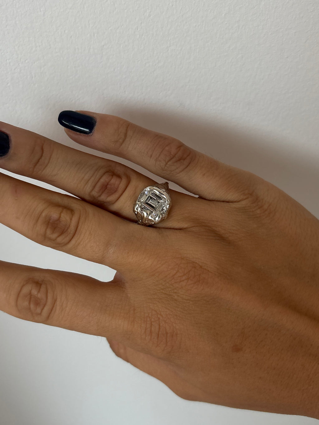 showing a sterling silver organic ring featuring a emeral cut zirconia