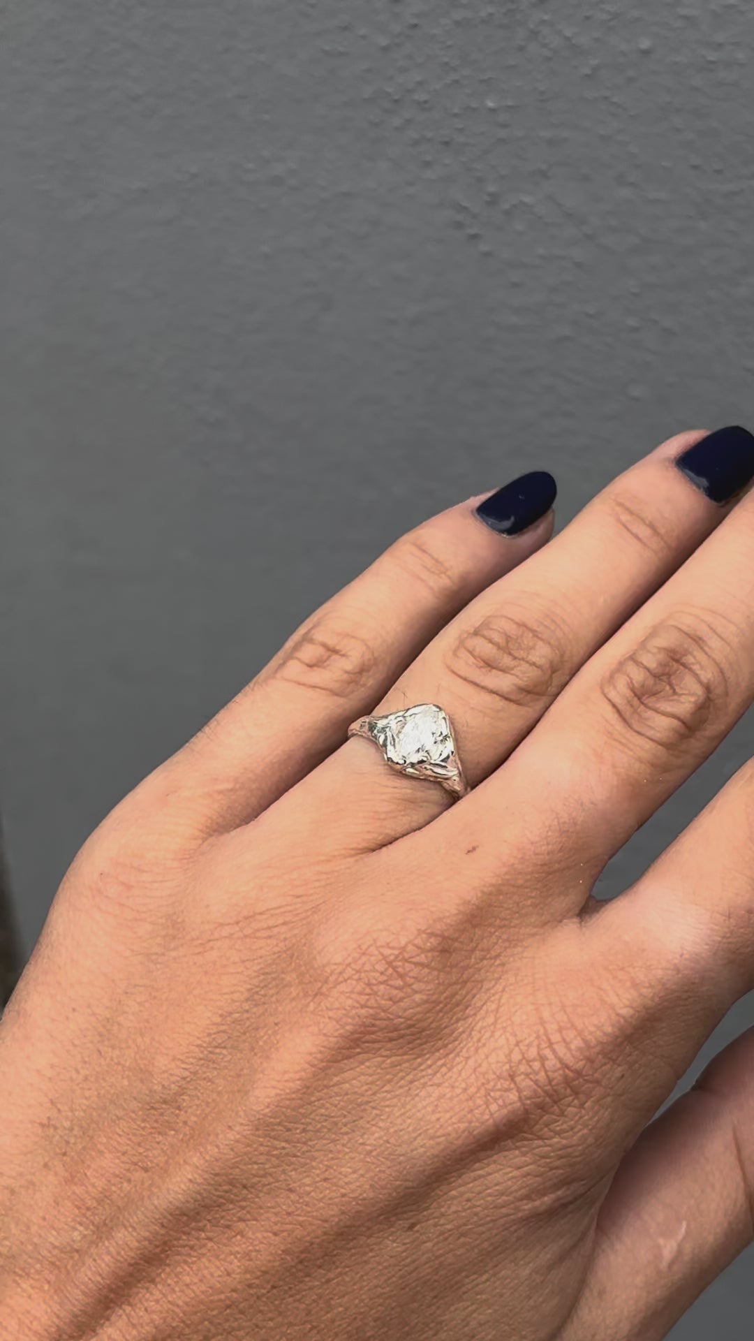 Hand wearing asterling silver ring featuring a marquise cut zirconia